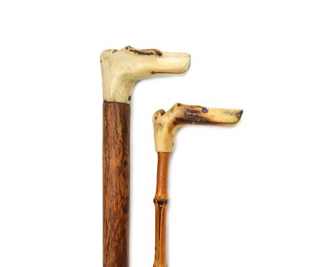 A carved horn 'dog's head' walking stick handle, early 20th century, with whistle to the rear and inset glass eyes, 87cm, and