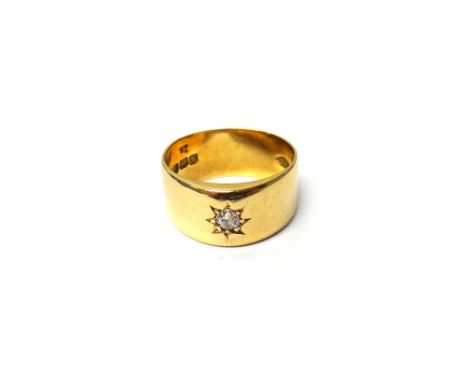 An 18ct gold and diamond set wide band ring, star gypsy set with a cushion shaped diamond, London 1916, ring size Q, gross we