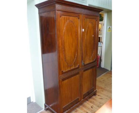 Early 20th Century mahogany Chippendale style wardrobe, the blind fret cornice above two panelled and blind fret doors on sli