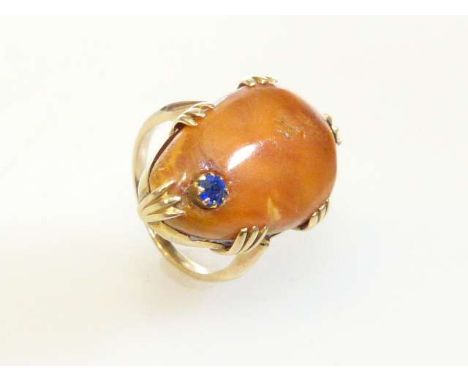 Amber-coloured ring set with a blue stone, size F½