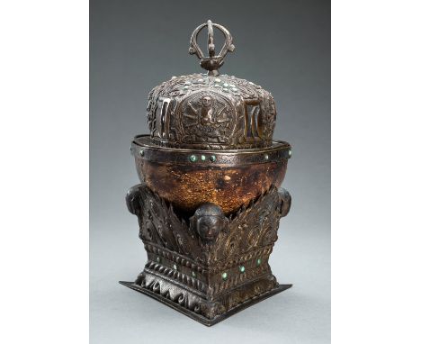 A COPPER MOUNTED KAPALA AND STAND, 19TH CENTURYTibet, 19th century. The copper trianagular flamiform stand with fierce heads 