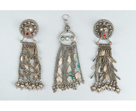 THREE TRIBAL AFGHAN METAL ORNAMENTS WITH INSETS, c. 1950sAfghanistan, mid-20th century. The group including a pair of ornamen