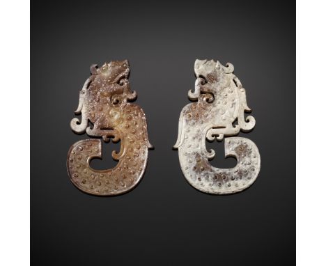 A PAIR OF JADE 'DRAGON' PENDANTSJade. China, Han dynasty, 206 BC - 220 ADEach pendant of this pair is carved in the shape of 