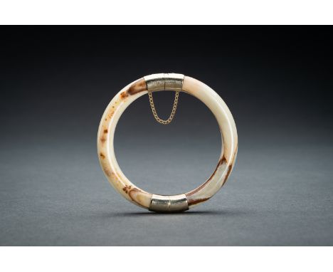 A FINE CHINESE AGATE BANGLEChina, 20th century. Of circular form, with gilt metal mounts. The stone of a semi translucent pal