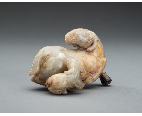 A CELADON JADE RAM GROUP, QINGChina, Qing Dynasty (1644-1912). Carved as two recumbent rams, the larger animal with its head 