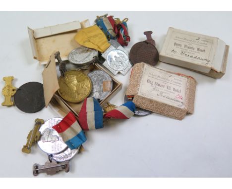 Thirteen school medallions to include Victorian, Edward and George, awarded to an M. Treadaway, some with ribbons