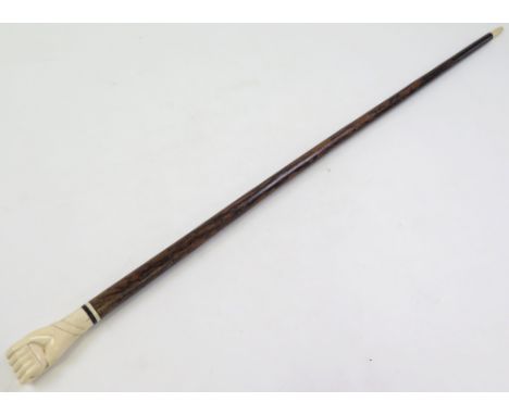 Malacca walking stick, circa early 20th century, with carved ivory (?) handle depicting a fist and entwined with a snake, len