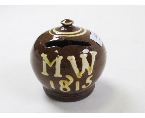 Slipware ceramic money box, circa 19th century, brown glaze with white glaze decoration 'MW 1815' to front, finial to top, a 