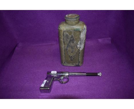 A vintage chromed GAT gun and similar cowboy styled flask