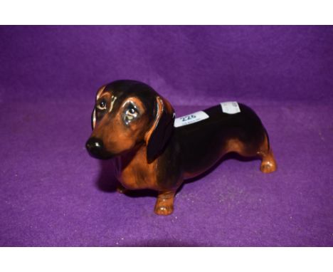 A ceramic figure study of a sausage dog by Royal Doulton in fine condition