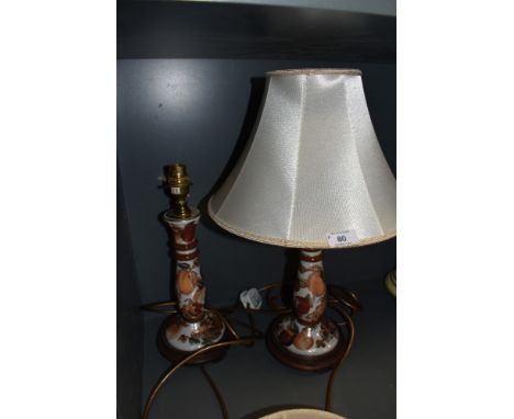 A pair of ceramic table lamps with shades having fruit design and gilt detailing.