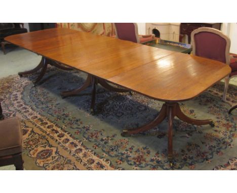 DINING TABLE, Regency oak circa 1820 with two extra leaves on triple ring turned pedestals with swept feet and brass cappings