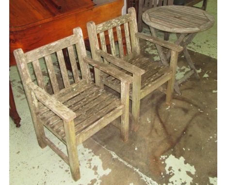 GARDEN ARMCHAIRS AND TABLE, a pair, weathered teak with square supports together with a circular folding table, 73cm H x 70cm