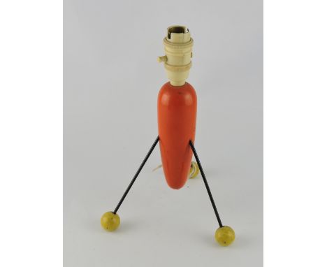 A tripod table lamp of post war inspiration in the manner of Robin Day, the torpedo shaped orange painted body on three black
