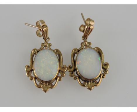 A pair of opal drop earrings, the oval cabouchon cut stones set within foliate 9ct gold frames, 5g.