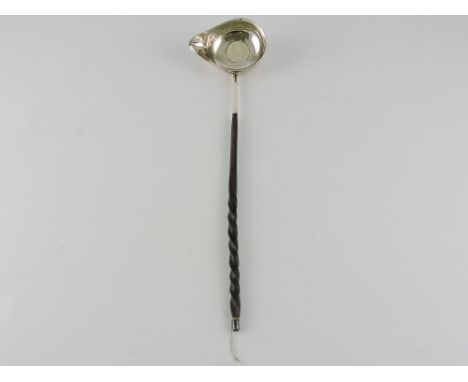 A Georgian punch ladle, the bowl inset with a coin and spout to the left, on a spiral twist handle.