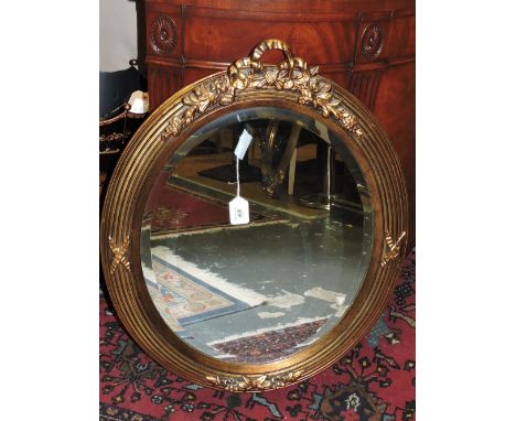 A Victorian style oval gilt frame wall mirror.