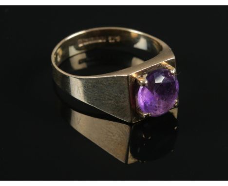 A boxed 9ct gold ring with a claw set Amethyst coloured stone. Size P, assayed in Birmingham. Gross weight: 3.75g.  