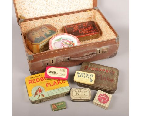 A vintage suitcase with contents of tins. Includes Redbreast Flake examples etc.  