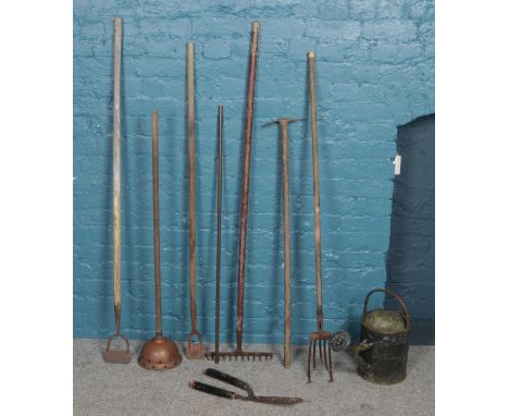 A collection of garden tools. Including rotavator, hoes, metal watering can, etc.  