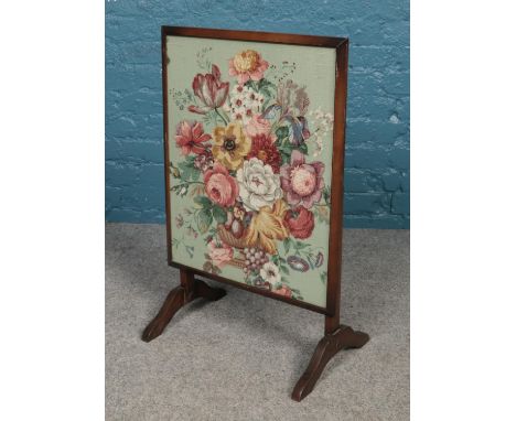 A folding fire screen with floral decorative panel.  
