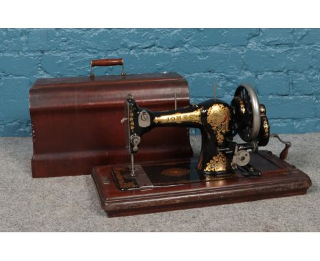 A vintage wooden cased Jones sewing machine. No. 351162.  