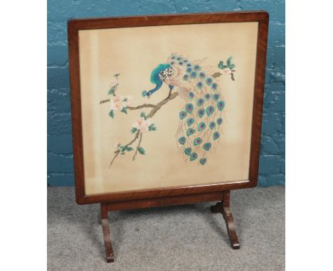 A metamorphic fire screen/table. With needle work panel depicting a peacock.  
