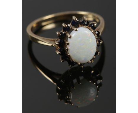 A 9ct gold opal and possibly Sapphire cluster ring. Assayed in Sheffield. Size N. Total weight: 2.38g.  