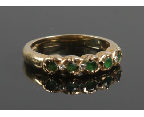 A 9ct gold emerald and diamond ring. Size M. 3.08g.  Missing one diamond.