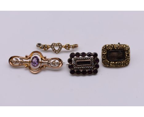 A garnet and seed pearl yellow metal mourning brooch; together with a Georgian example dated 1816; an amethyst and seed pearl