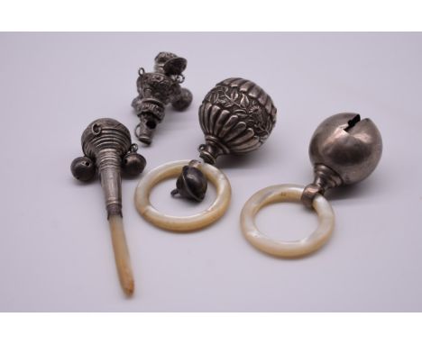 Two silver and mother of pearl teething rings; together with a mother of pearl and metal teething stick; and part of a baby's