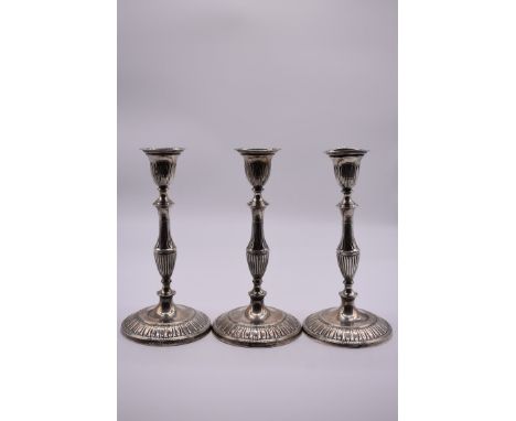 A set of three Adam style silver candlesticks, by Harrison Brothers &amp; Howson, Sheffield 1924, 26cm high, weighted. 