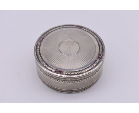 An engine turned silver gilt lined box, decorated amethysts, import mark for London 1906, 6cm diameter, 77g gross weight. 