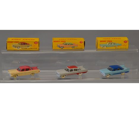 Three Dinky Toys: #178 Plymouth Plaza in light blue with dark blue roof and side flash; #180 Packard Clipper Sedan in cerise 