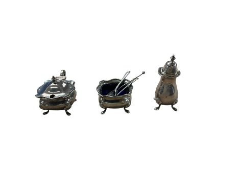 1920s silver three piece part cruet set, comprising pepper shakers, open salt with blue glass liner and a mustard pot, all up