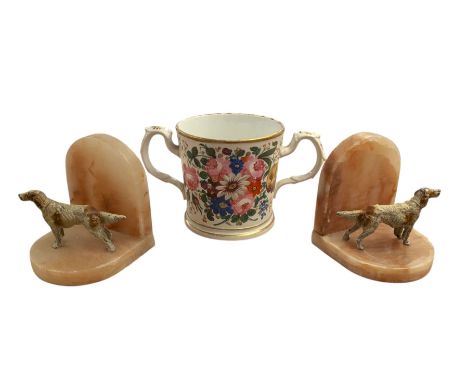 Pair of Art Deco dog bookends and a twin handled loving cup, painted with floral decoration and quote, loving cup H14cm