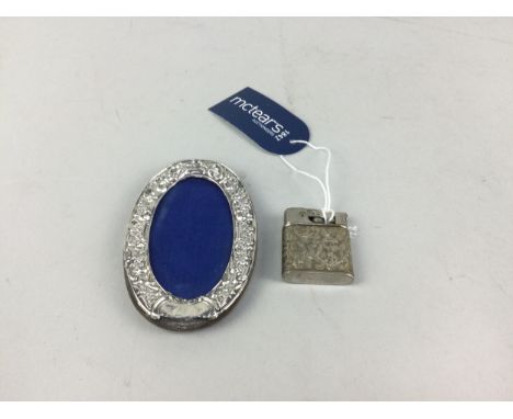 SILVER OVAL PHOTOGRAPH FRAME, 10cm x 6.5cm, along with a vintage Baby-Mylflam patent cigarette lighter (2)