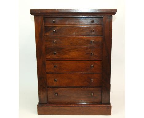 A VICTORIAN MAHOGANY GRADUATED SEVEN DRAWER COLLECTORS CABINET with vertical hinged flaps, each drawer with individual conten