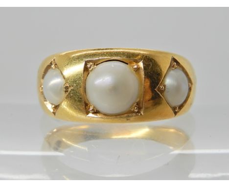 AN 18CT GOLD THREE PEARL RING the inner shank stamped 18c T.B with a right hand in a shield. Three natural half pearls grain 