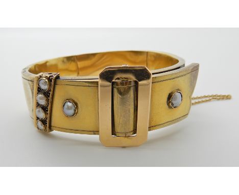 A BRIGHT YELLOW METAL PEARL SET BUCKLE DESIGN BANGLE inner diameter 5.5cm x 4.9cm, weight 26gms Condition Report: Has multipl