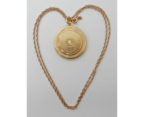 A 15CT GOLD LOCKET WITH A 9CT GOLD ROPE CHAIN diameter of the locket 3cm with all over engine turned engraving with hand cut 