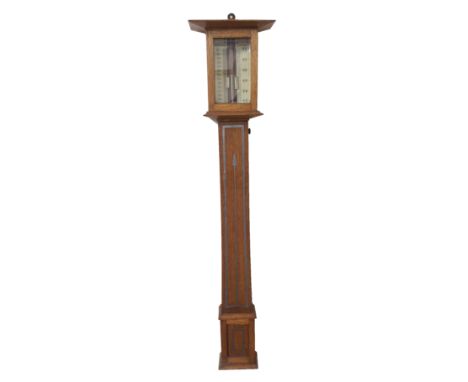 AN ARTS AND CRAFTS STYLE OAK AND PEWTER INLAID BAROMETER the mercury tube flanked by ivory scales for centimetres and inches 