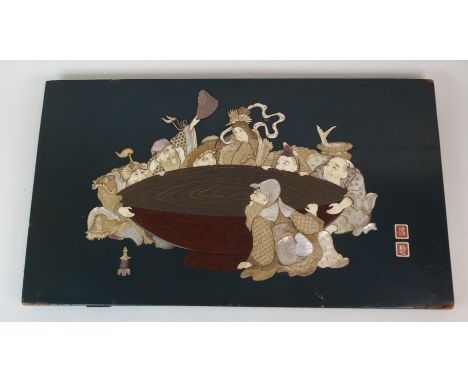 A JAPANESE LACQUERED, IVORY AND SHELL PLAQUE depicting The Goddess Kannon and six men drinking from a large basin, signed (da