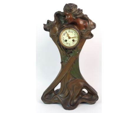 A FRENCH ART NOUVEAU TIMEPIECE the patinated spelter case modelled as a maiden with central clock, the enamel dial with paint
