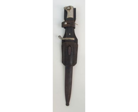 A WWII GERMAN BAYONET maker's mark WKC, the chequered Bakelite hilt with plated bird's head, pommel in black painted scabbard