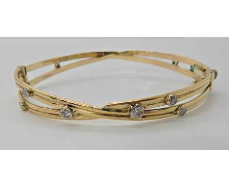 A 9CT HAND MADE BANGLE SET WITH DIAMONDS AND AN EMERALD by Sheana M. Stephen Edinburgh, set with estimated approx 0.30cts of 