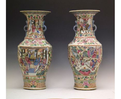 Pair of large Famille Rose baluster shaped vases, each having two reserves with court and warring figures on a foliate decora