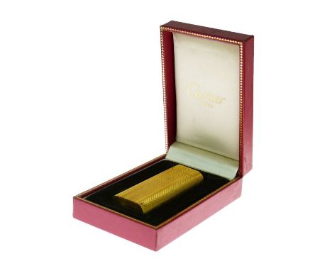 Les Must de Cartier gold plated cased gas cigarette lighter with engine turned decoration, 7cm high, cased and with paperwork