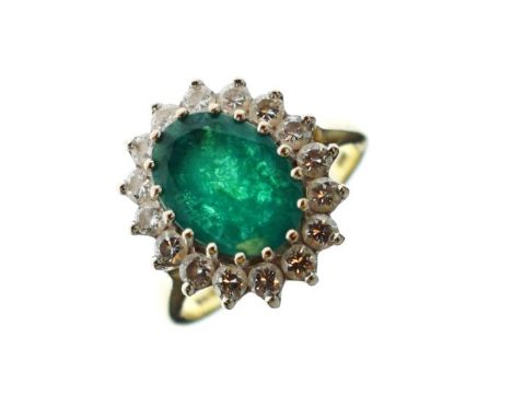 Emerald and diamond 18ct gold cluster ring, the oval cut measuring approximately 10mm x 8mm x 3.2mm deep, enclosed by sixteen