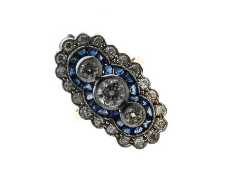 Diamond and calibré sapphire panel 18ct gold ring, the central brilliant cut of approximately 0.65 carats, flanked either sid